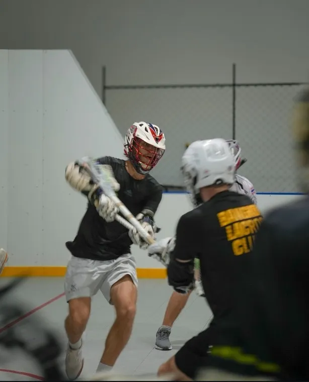 Two helmeted players contest possession during indoor training